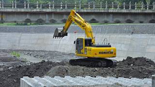 Komatsu PC210 Excavator Working On The River Bank Reinforcement Construction