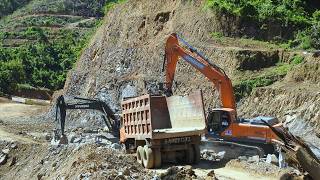 Excavator Trucks Excavating Dirt Through The Hill On The New Road Construction Site